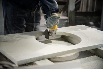 Man polishing marble stone table by small angle grinder. Stone cutter